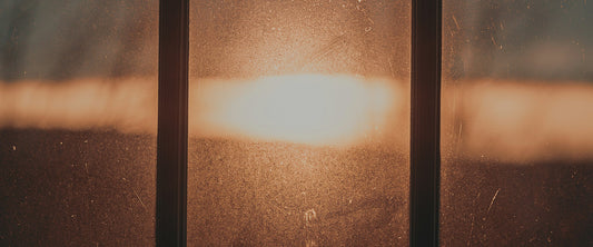 Soft early morning sunlight streaming through a window into a dim, quiet room