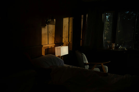 A dimly lit, calm bedroom at dawn with soft light coming through the window — quiet spring morning setting for restful, easy nasal breathing.