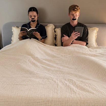 Couple asleep in bed wearing 18pointthree mouth tape