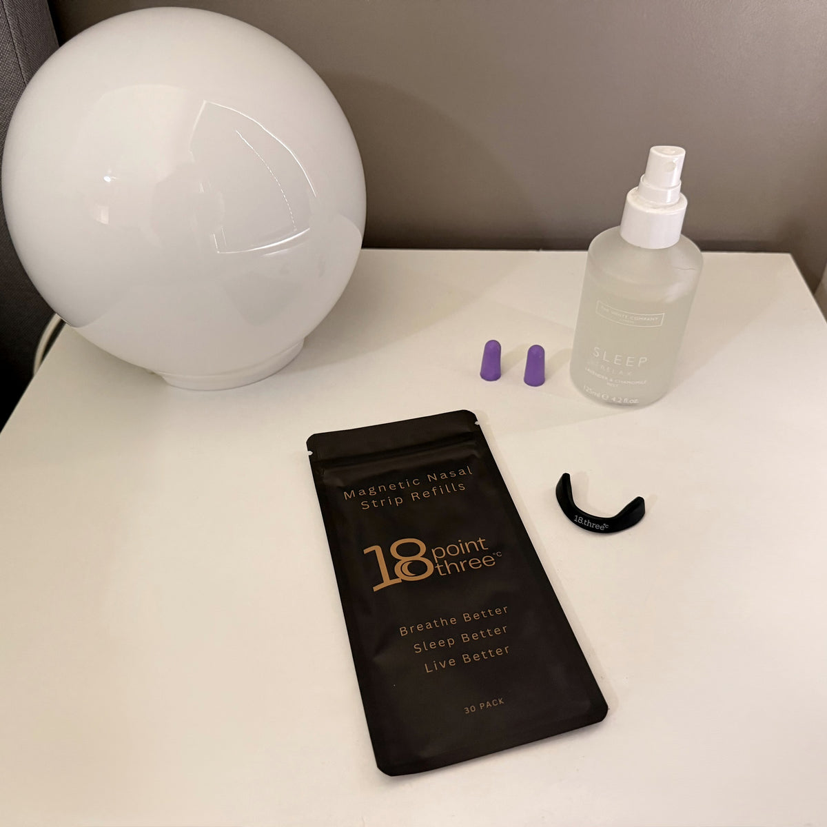 18pointthree Magnetic Nasal Strip Refills on a bedside table at night