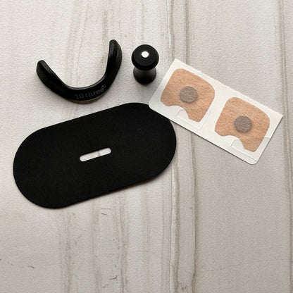 Magnetic frame, magnet, adhesive patches and a piece of mouth tape laid out together