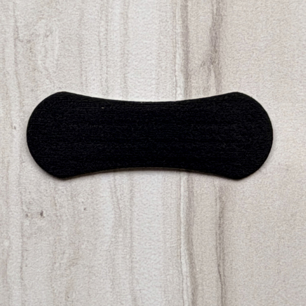 Close-up of a single 18pointthree nasal strip on stone showing the fabric weave