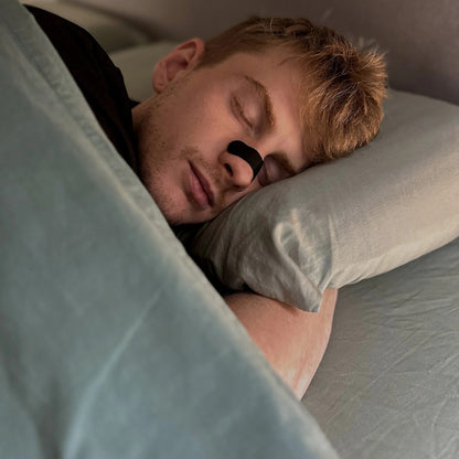 Man asleep wearing an 18pointthree Nasal Strip