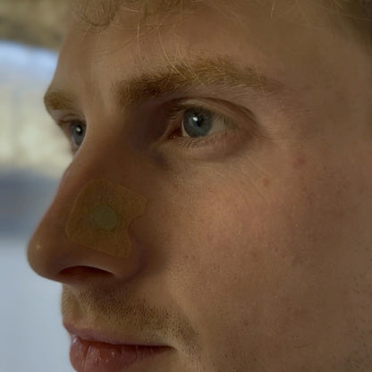 Close-up of an 18pointthree magnetic nasal strip refill patch applied to the side of the nose