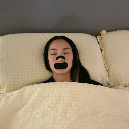 Overhead view of a man asleep wearing an 18pointthree nasal strip